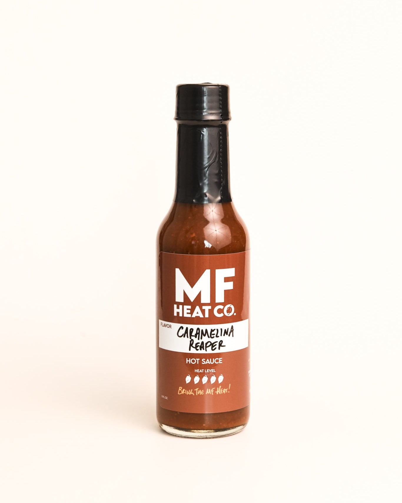 Bottle of MF Heat Co. Caramelina Reaper hot sauce on a white background